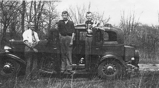 Michael Vogl and two sons by an old car, , Wisconsin, 1945